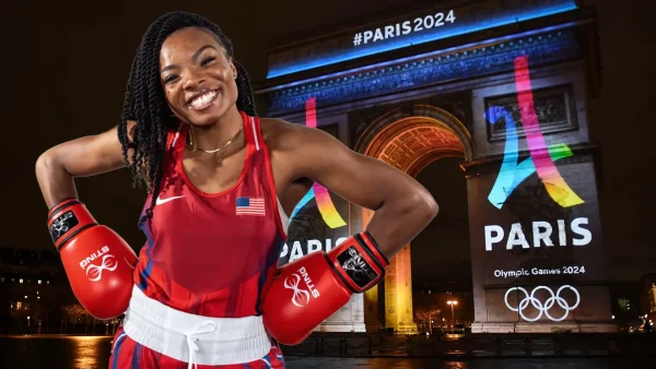 American boxing Olympic team mate standing in front of the Paris Arc de Triomphe lit up with the Paris Olympic 2024 signs.